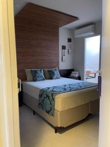 布拉干萨-保利斯塔Green It Motel & Hotel的一间卧室配有一张大床和木制床头板