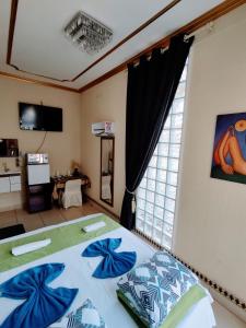 大坎普Pousada AM PM的一间卧室配有一张带蓝色枕头的床和一扇窗户。