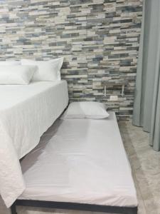 La LomaApartamento Turistico Soul的一间卧室设有两张床和砖墙