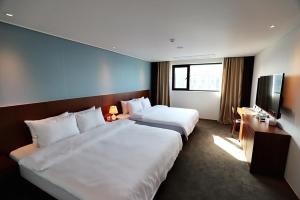 仁川市海月旅游酒店 的酒店客房设有两张床和一台平面电视。