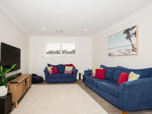 卡拉拉海滩Havenwood - Pet Friendly - Spa & Community Pool的客厅配有2张蓝色沙发和1台平面电视