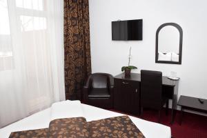 奥拉迪亚特拉酒店的一间卧室配有书桌、椅子和镜子