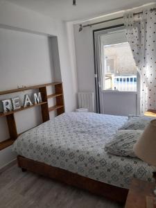 阿罗芒什莱班le neptune的一间卧室设有一张床和一个窗口