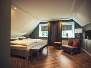 比勒费尔德施里克特霍夫酒店有限公司的一间卧室配有一张床、一把椅子和窗户。