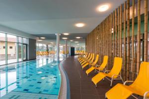 什图罗沃Wellness Hotel Thermal的一座带黄色椅子的游泳池