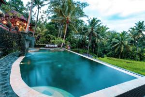塔巴南尤马赛瑞瑞斯特里斯别墅酒店的棕榈树度假村内的游泳池