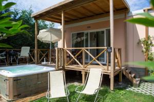 伊塞奥Camping Del Sole Village的一个带甲板和热水浴池的泳池别墅