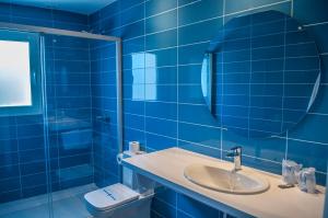 桑特柳伊斯HOSTAL XUROY的蓝色瓷砖浴室设有水槽和镜子