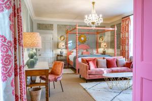 诺里奇阿森贝利酒店的一间卧室配有粉红色的床和粉红色的沙发