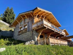 莱热Chalets Alaska的一座位于山丘上的大型木屋,设有阳台