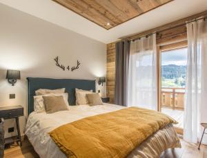 莱热Chalets Alaska的一间卧室设有一张大床和大窗户