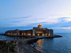 Torre RitaniOstello Bella Calabria的夜中海洋中的城堡