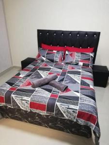 阿曼济姆托蒂Afsaal flats的床上有五颜六色的被子和枕头