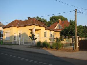 布达佩斯Aranyosház-Vendégház的前面有栅栏的黄色房子