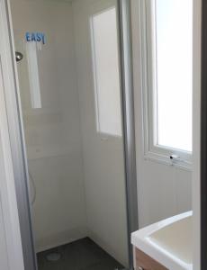 翁赞Assist' Mobil Home 377 - Mobil Home 3 chambres 6 Personnes的带淋浴和盥洗盆的浴室以及窗户。