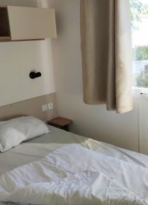 翁赞Assist' Mobil Home 377 - Mobil Home 3 chambres 6 Personnes的卧室配有白色的床和窗户