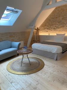 Cinq-Mars-la-PileLes Hauts de Grillemont的一间卧室配有一张床、一张桌子和一张沙发