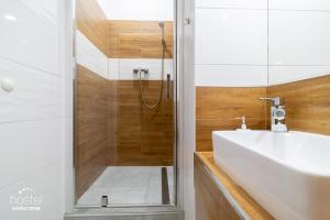 卡托维兹特卡托维兹中心旅馆的带淋浴和白色盥洗盆的浴室