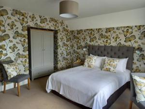 法尔茅斯特雷拉瓦酒店的一间卧室配有一张大床和一把椅子