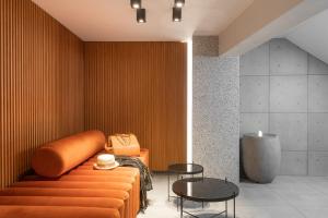 雅典11 Enteka Acropolis Suites的配有橙色沙发和桌子的房间