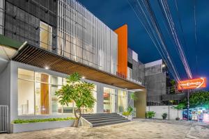 日惹Sans Hotel Prime Cailendra Yogyakarta by RedDoorz的前面有棵树的建筑