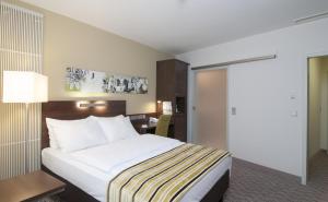 安达赫治慕尼黑翁特哈井假日酒店的配有一张床和一张书桌的酒店客房