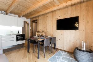 蓬泰迪莱尼奥Miki's Home - 2 bagni e giardino privato的厨房配有桌椅,墙上配有电视