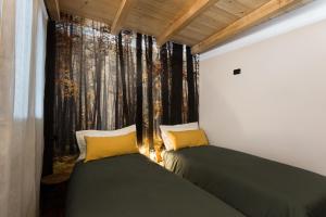 蓬泰迪莱尼奥Miki's Home - 2 bagni e giardino privato的带森林窗户的客房内的两张床