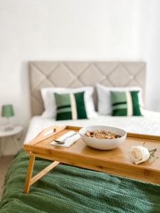 Madalena do MarThe Palms Apartment的床上的木托盘上放着一碗食物