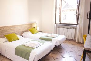 诺瓦拉Hotel Tornielli 9的两张床位于带窗户的房间内