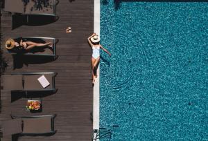 斯普利特马维尔健康酒店的站在游泳池旁的水面上的女人