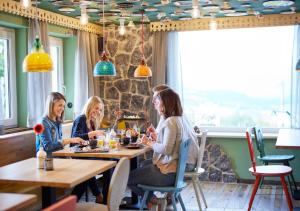 雷滕贝格KUKU Berghotel的坐在餐厅桌子上的三个女人