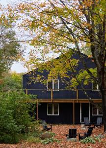 斯托Tälta Lodge, a Bluebird by Lark的一座黑色外墙和树木的房子