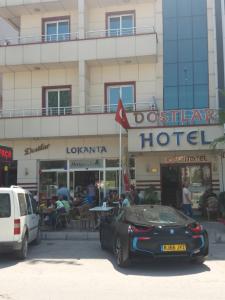 梅尔辛Dostlar Hotel的停在酒店前的一辆黑色汽车