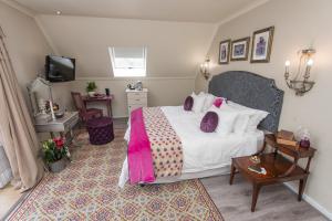 斯泰伦博斯巴鲁克宾馆的一间卧室配有一张床、一张桌子和一台电视。