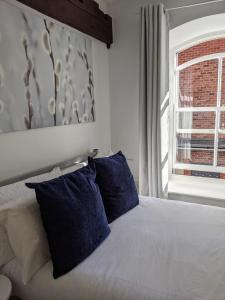 约克Riverside Apartment York的一间卧室配有一张带蓝色枕头的床和一扇窗户。