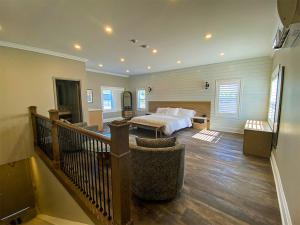 格兰湾Colonial Hotel & Suites的一间设有床铺和楼梯的大卧室