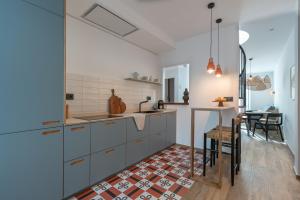 马拉加Attic Oasis的厨房配有蓝色橱柜、桌子和用餐室。