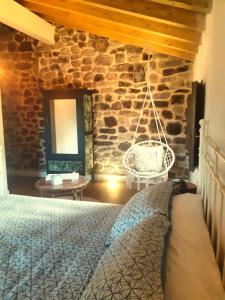 MolledoLA POSADA DEL TENOR的一间卧室设有一张床和石墙