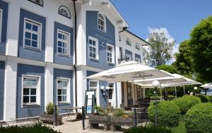 基姆湖畔普林Hotel Luitpold am See的蓝白色的建筑,带雨伞