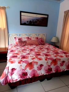 克莱因蒙德36 Df Strauss Street的一间卧室配有一张带粉红色花卉床罩的床。