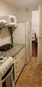 门多萨Departamento céntrico Mendoza的厨房配有炉灶和冰箱。
