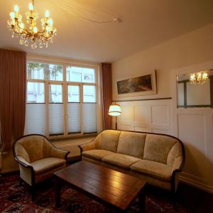 奥斯特罗德Barrierefreie Unterkunft - Fachwerk mit Flair的客厅配有沙发、桌子和吊灯。