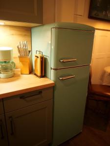 奥斯特罗德Barrierefreie Unterkunft - Fachwerk mit Flair的柜台旁厨房里的绿色冰箱