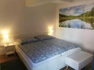 瓦伦Appartementhaus 10 Seen的卧室配有一张床,墙上挂有绘画作品