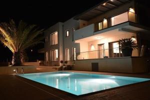 罗维尼Villa Valsavia-apartment Monsena with pool and SPA的一座大型游泳池,在晚上在房子前面