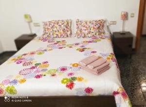 里奥帕尔CASAS RURALES EMILIO的一张床上的白色毯子,上面有鲜花