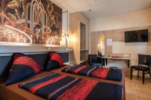 维勒斯威特Land-Hotel Zum Schwan, Garni WEILERSWIST-METTERNICH的配有一张床和一张书桌的酒店客房