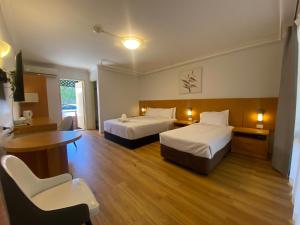 悉尼悉尼花园酒店的酒店客房带两张床和一张桌子以及椅子。
