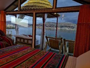 普诺Uros Qhota Uta Lodge的一间卧室配有一张桌子,享有水景